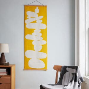 Modern yellow and white abstract wall art in a cozy room.