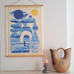 Abstract blue and yellow wall art with a modern ceramic vase beside a candle.