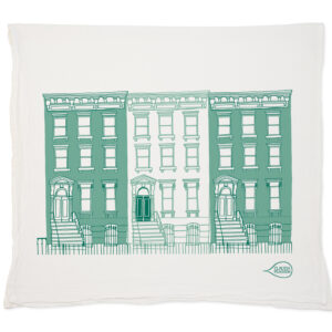 Decorative pillow with green townhouse illustration.