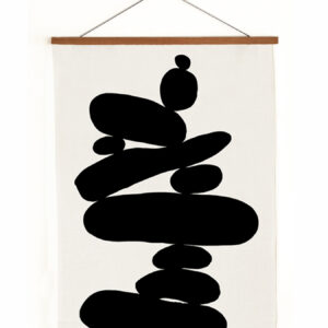 Abstract black shapes stacked on white canvas wall hanging.