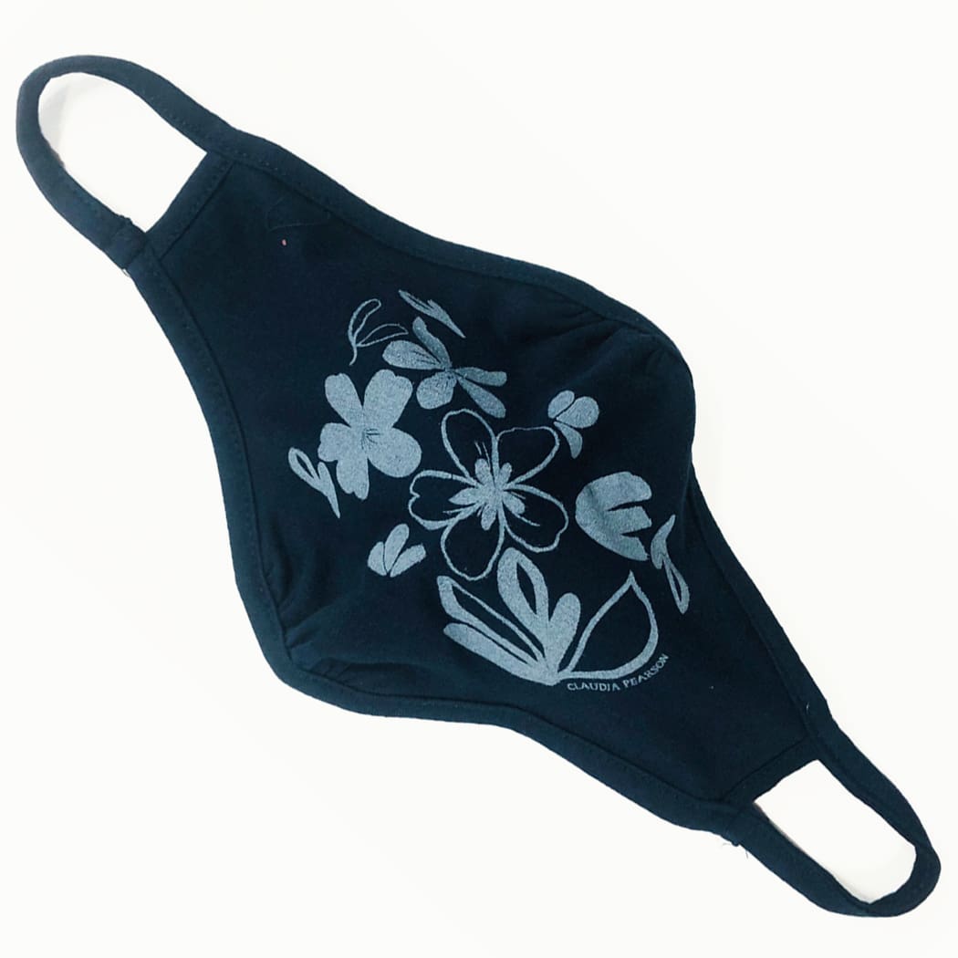 Black face mask with white floral design and ear loops.