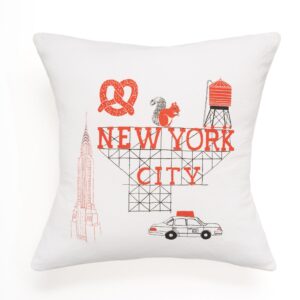 Decorative pillow featuring New York City-themed illustrations and text.