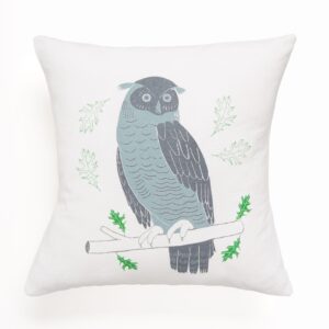 Decorative pillow with a stylized owl perched on a branch.